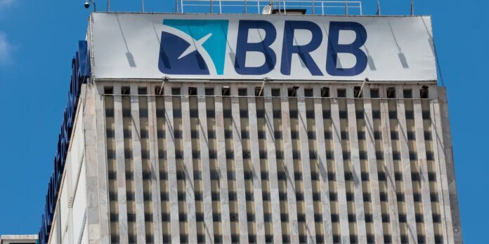 High-rise building with a large BRB sign on the roof beneath a white banner and blue sky.