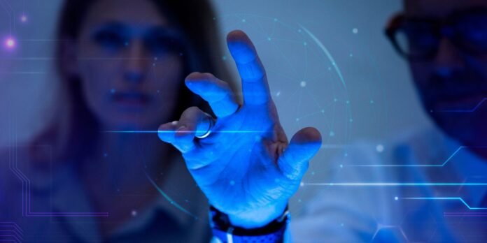 Blue-gloved hand reaching toward a glowing holographic network interface in a lab setting, with a person in the background.