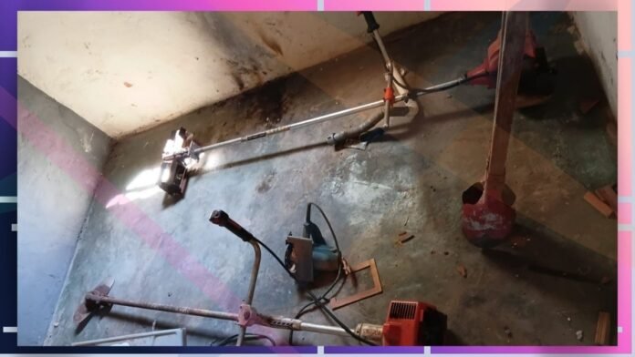 Cluttered concrete basement floor with scattered power tools and metal poles.
