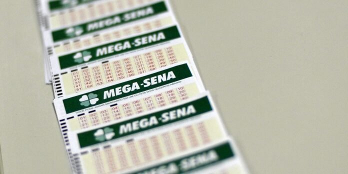 Row of MEGA-SENA lottery tickets fanned out on a light surface with green banners and numbers visible
