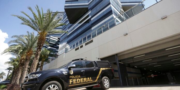 Black Policia Federal pickup truck parked outside a modern glass-front building with palm trees along the sidewalk on a sunny day.