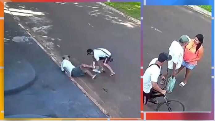 People assist a person lying on a sidewalk curb while two bystanders bend over to help