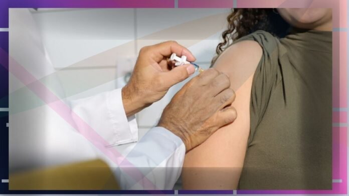 A clinician administers a vaccine into a person's upper arm.