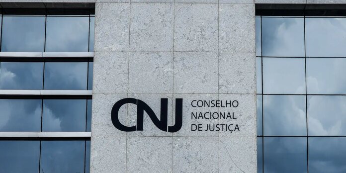 Facade of a modern building featuring the CNJ logo and the words 'Conselho Nacional de Justiça' on a gray granite panel.