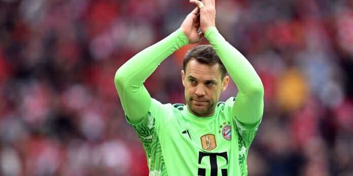 Bayern Munich goalkeeper in a neon green kit applauds with hands raised during a match. (Manuel Neuer)