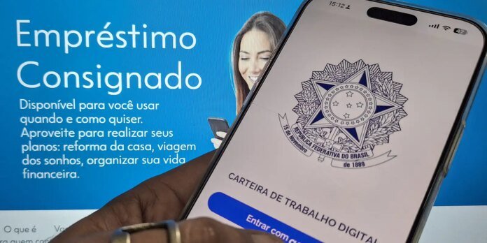 Smartphone screen showing the Brazilian Carteira de Trabalho Digital app logo, held in front of a blue loan advertisement.