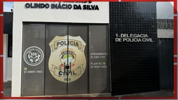 Front of a Polícia Civil building with a large shield emblem on glass doors and the sign '1ª Delegacia de Polícia Civil' on a black tiled wall, Mato Grosso do Sul MS.