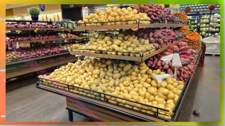 Potatoes stacked on a multi-tier supermarket display, with yellow potatoes in front and red potatoes behind in the produce section