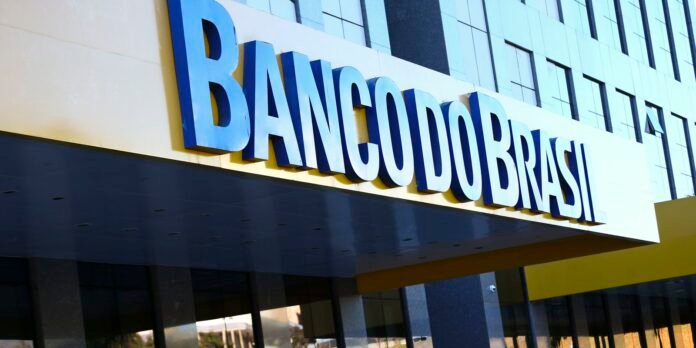 Modern bank storefront with oversized blue letters spelling 'BANCO DO BRASIL' on a white sign above a dark entrance.