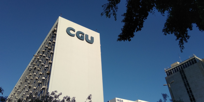 Tall white office building with a CGU logo angled against a clear blue sky, with trees and another building nearby.