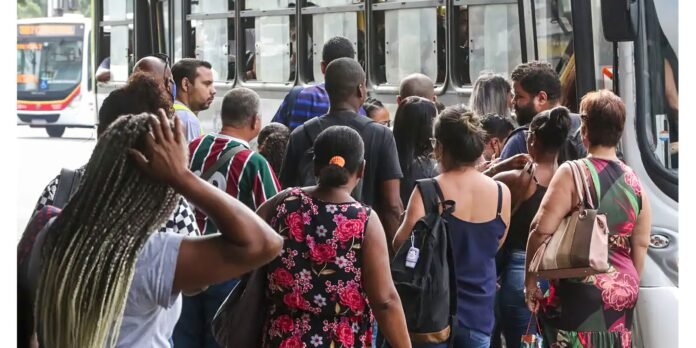 Crowded bus doorway with diverse commuters boarding, carrying bags and backpacks.