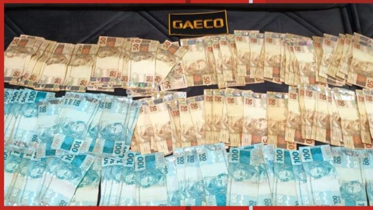 Stacks of Brazilian real banknotes in beige and blue tones arranged on a dark surface with a GAEC0 label visible on top.