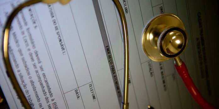Stethoscope resting on a medical form with field labels, overlaid Portuguese text.
