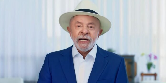 Senior man in a white hat, white shirt, and blue blazer speaks to the camera in a bright room.