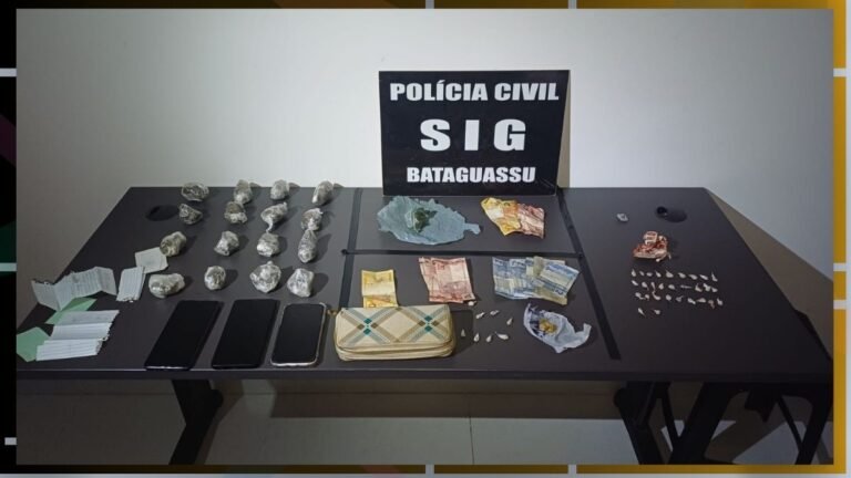 Table displaying seized items: small wrapped packages, cash, multiple mobile phones, a striped wallet, papers, and a sign reading 'Polícia Civil SIG Bataguassu'.