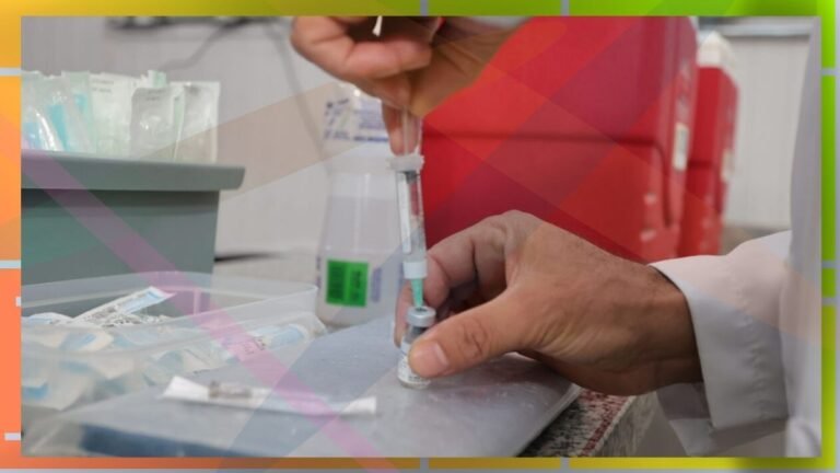 Healthcare worker drawing liquid from a vial into a syringe at a clinic counter
