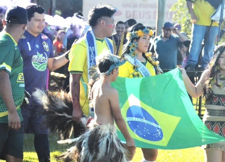 Parade scene with people in yellow shirts; a girl wearing a flower crown holds a Brazilian flag in the foreground.