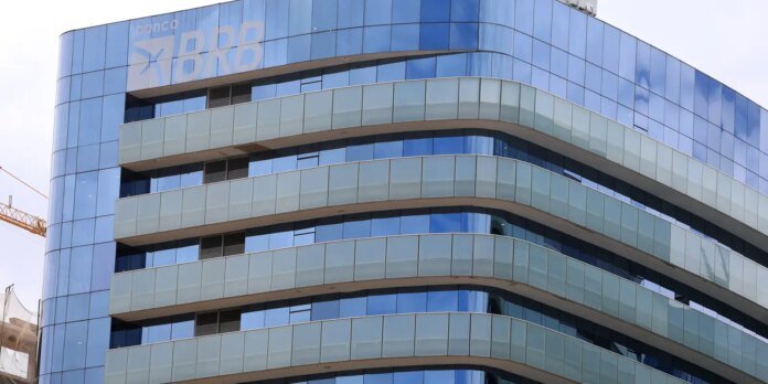 Modern glass office building with curved white bands and a BRD logo on the top-left corner at banco BRD