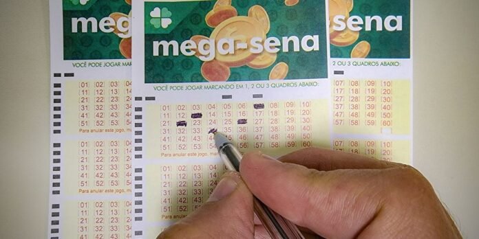 Person marking numbers on Mega-Sena lottery cards with a pen, selecting 1, 2 or 3 grids on printed tickets