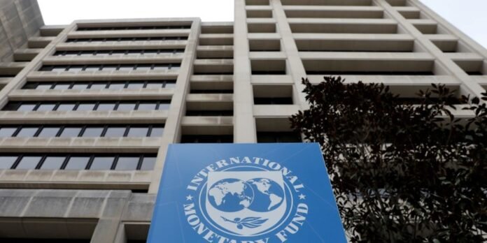 Tall office building with a large blue International Monetary Fund sign featuring a globe logo in the foreground
