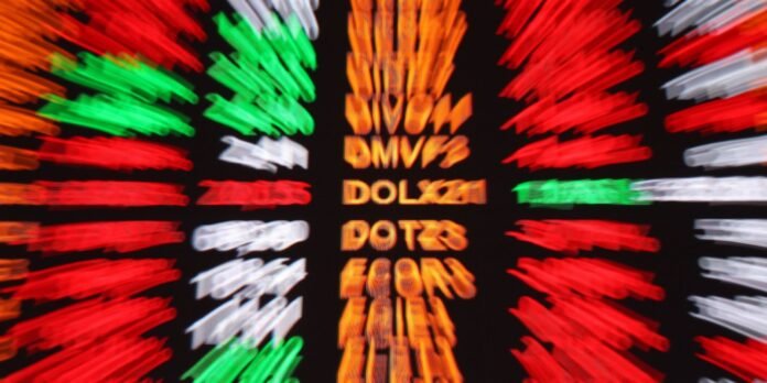 Blurred stock ticker board with red, green, and orange scrolling quotes across a dark background.