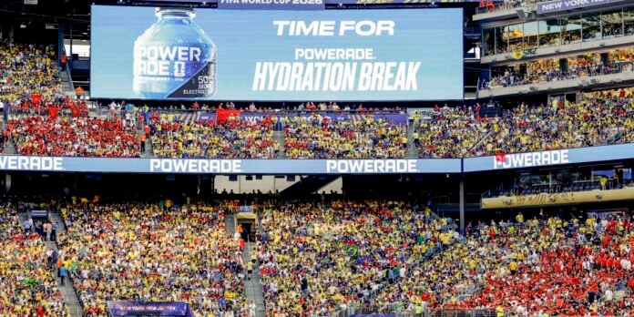 Massive stadium scoreboard reading 'Time for Powerade Hydration Break' over a packed crowd of fans.