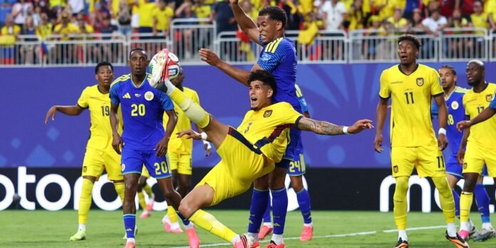Soccer players in yellow and blue battle for the ball in a crowded match, one yellow player kicking high as a blue opponent challenges.