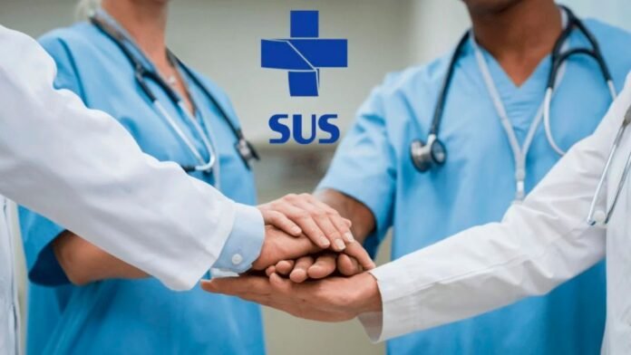 Medical team in blue scrubs join hands in a gesture of teamwork, with a SUS logo in the background.