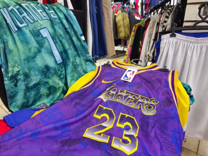 Purple and gold Los Angeles Lakers basketball jersey with number 23 on display in a clothing store.
