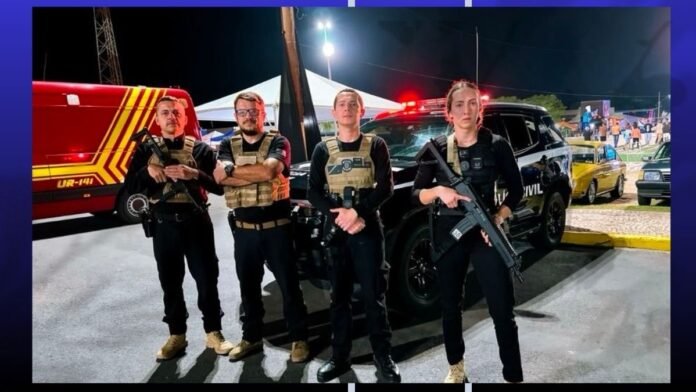 Four armed security personnel in tactical vests stand in front of a black SUV at a nighttime event.