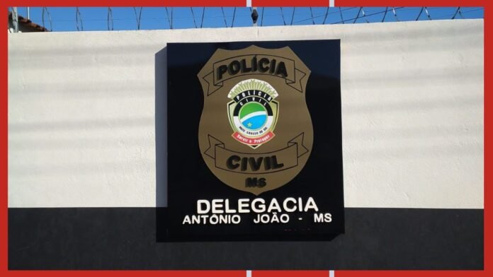 Polícia Civil badge on a black plaque mounted on a white wall; barbed wire on top.