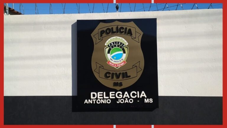 Polícia Civil badge on a black plaque mounted on a white wall; barbed wire on top.