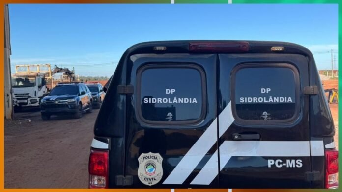 Back of a black police van with DP Sidrolândia and PC-MS markings, badge visible, on a dirt road with other vehicles in the background.