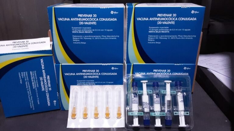 Six blue boxes labeled Prevenar 20 vaccine with a blister pack of syringes and vials in front.