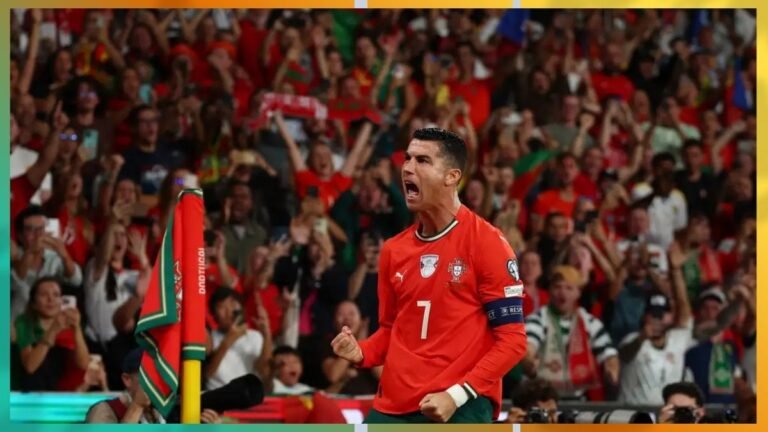 Portugal goalkeeper in a red kit (number 7) celebrates with fists clenched as fans cheer behind him.