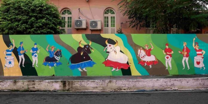 Vibrant mural of dancers in bright costumes with stylized bulls and horses on a rainbow backdrop.