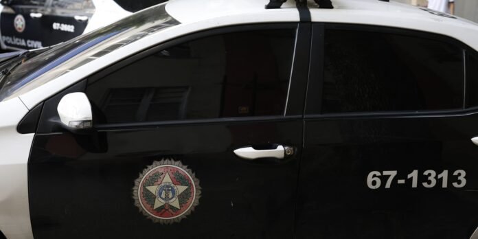 Black-and-white police car with emblem on the front door and the number 67-1313 visible on the side, tinted windows.