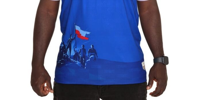 Man wearing a blue athletic shirt with a graphic of climbers and a small flag on the lower back hem.