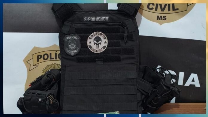 Black tactical police vest with patches reading 'FORHONOR' and 'POLÍCIA CIVIL MS' plus a skull emblem, shown against a police banner background.