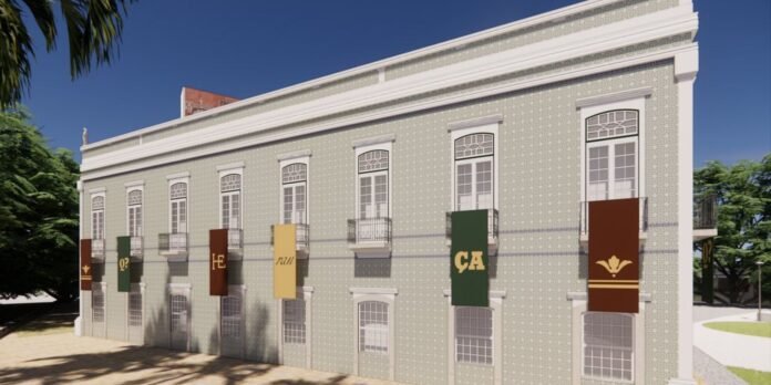 Exterior view of a historic-style gray tiled building with white trim, arched windows and small balconies, each floor displaying colorful banners