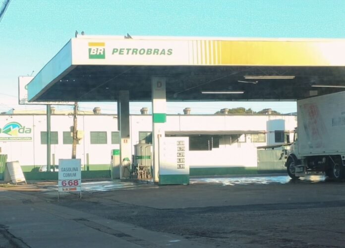 Petrobras gas station with a delivery truck at the pump and a price board nearby, sunny day.
