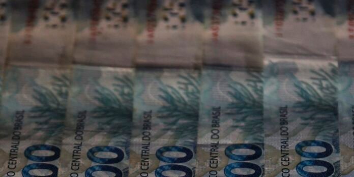 Several Brazilian banknotes showing the blue-green 1000 reais design, stacked and overlapped.