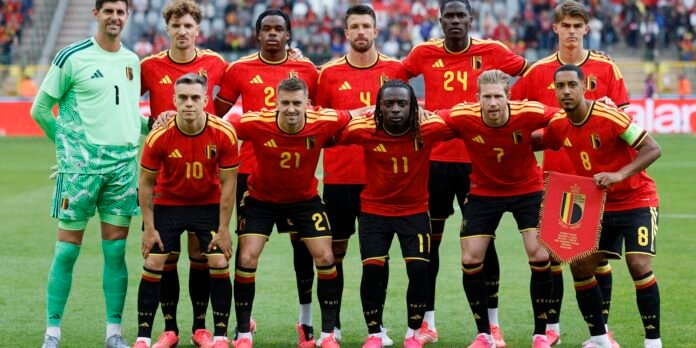 Belgian national football team posing for a group photo on the field before a match, in red jerseys with the crest visible.