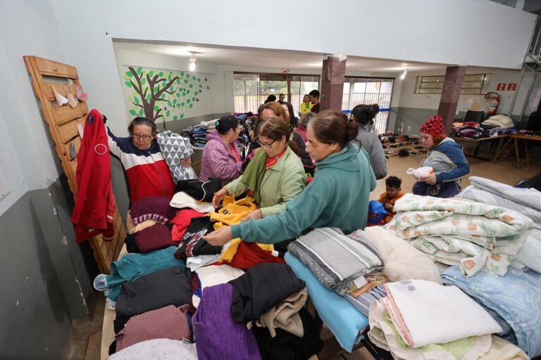 Group of volunteers sorting and folding donated clothes at a clothing drive in a community center to help those in need.