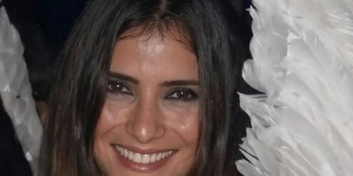 Close-up of a smiling woman with long dark hair facing the camera.