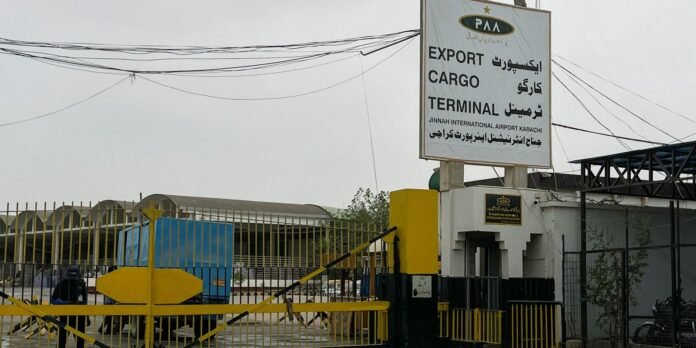 Cargo terminal gate at Jinnah International Airport Karachi, with yellow barriers and a tall sign reading EXPORT CARGO TERMINAL.