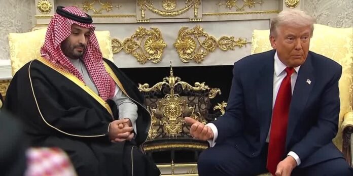 Two men sit on ornate gold chairs in a luxurious room; one in traditional Middle Eastern attire with a red-and-white headdress, the other in a dark suit and red tie, their hands joined in a brief handshake or clasped gesture.