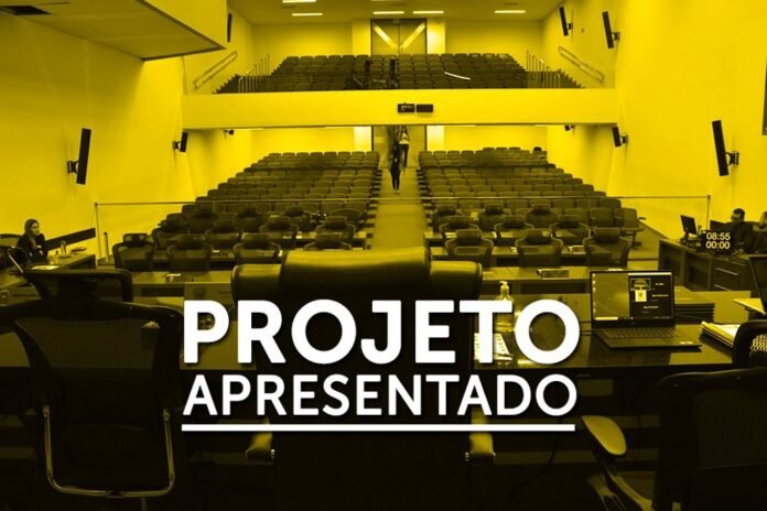 Empty lecture hall with desks and rows of seats, seen from the presenter’s desk; bold 'PROJETO APRESENTADO' overlay.