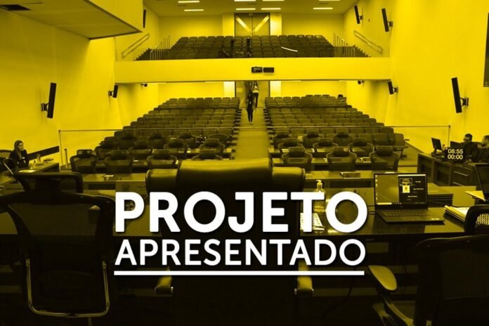 Auditorium with tiered seating and a front desk; large white text 'PROJETO APRESENTADO' overlays the scene.