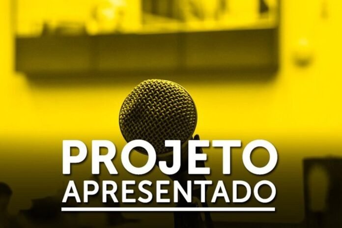 Yellow-tinted presentation slide featuring a close-up microphone in the foreground and bold white text reading 'PROJETO APRESENTADO' with an underline.